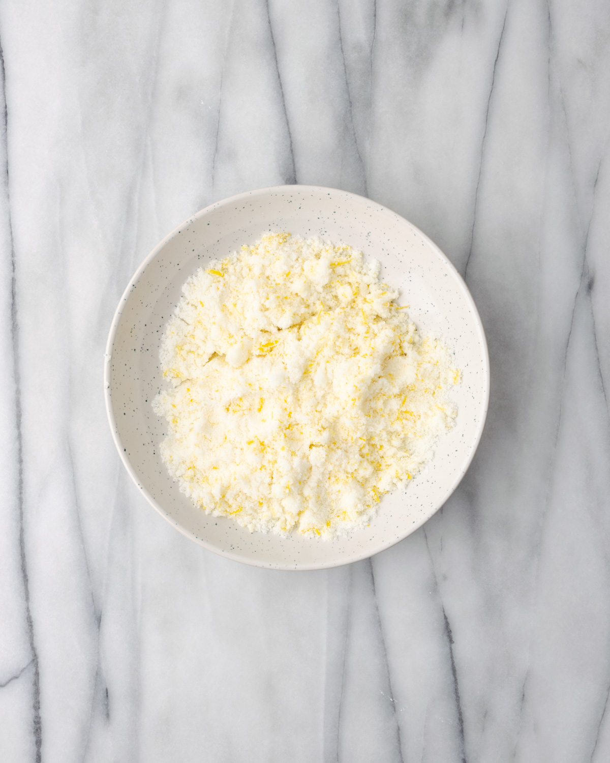 A bowl a light yellow colored lemon sugar.