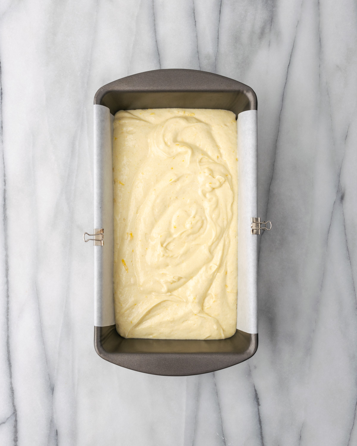 Lemon cake batter spread into a 9x5 loaf pan.