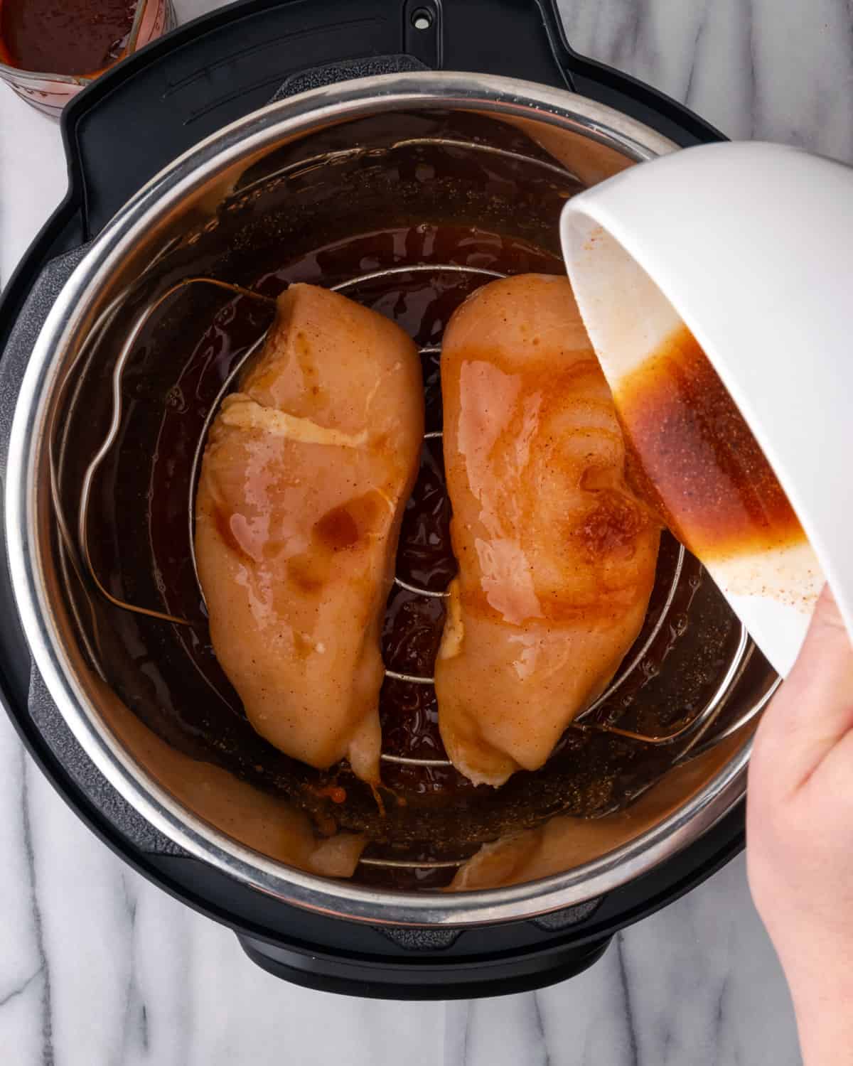 Uncooked chicken breast inside an instant pot.