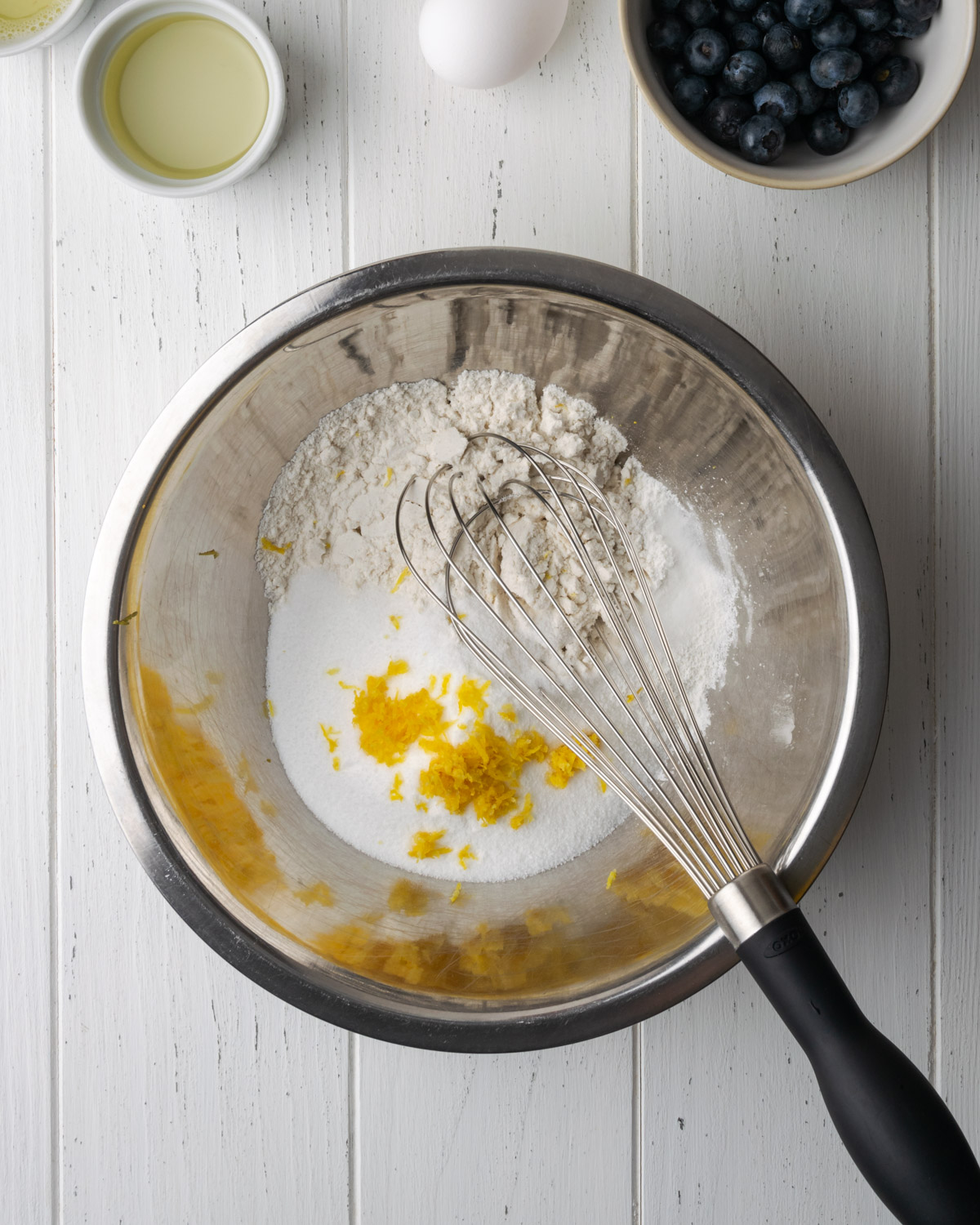 Flour and lemon zest in a metal bowl.