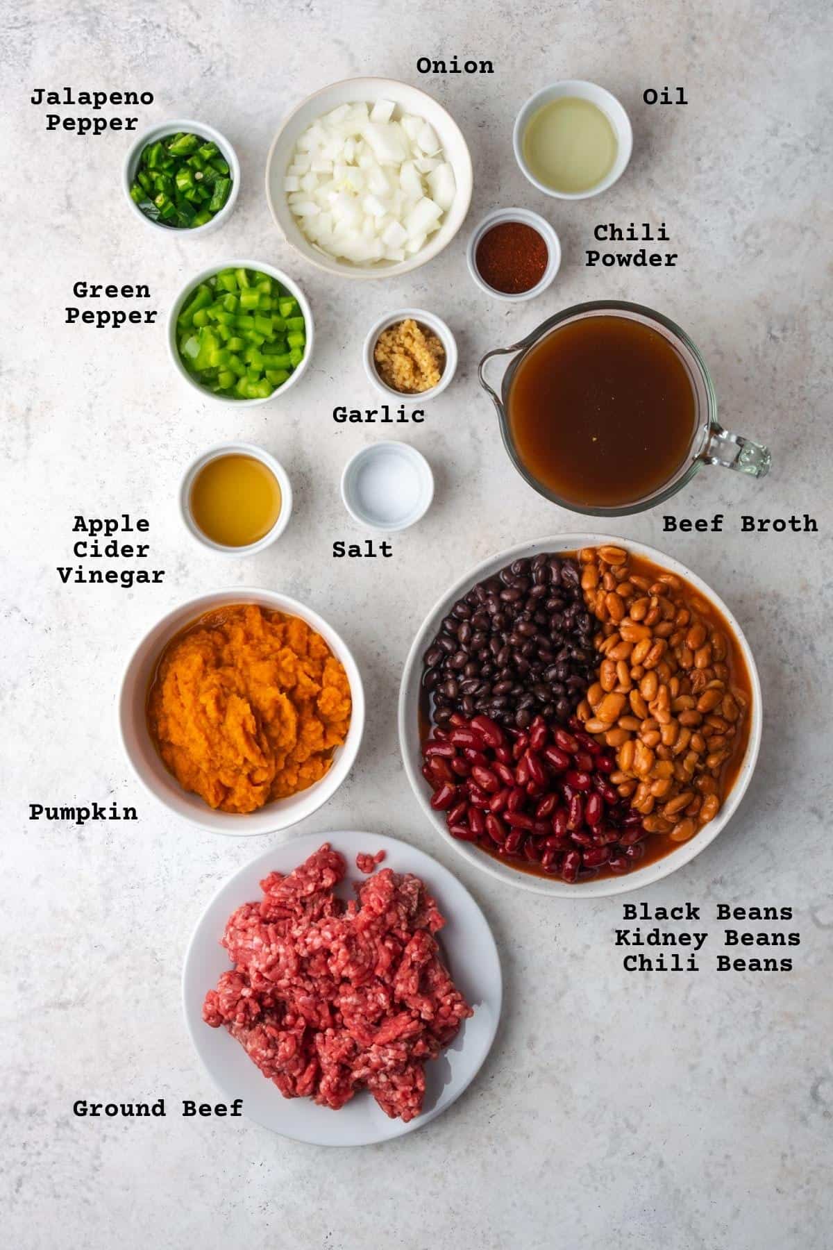 Ingredients for pumpkin chili on a white table.