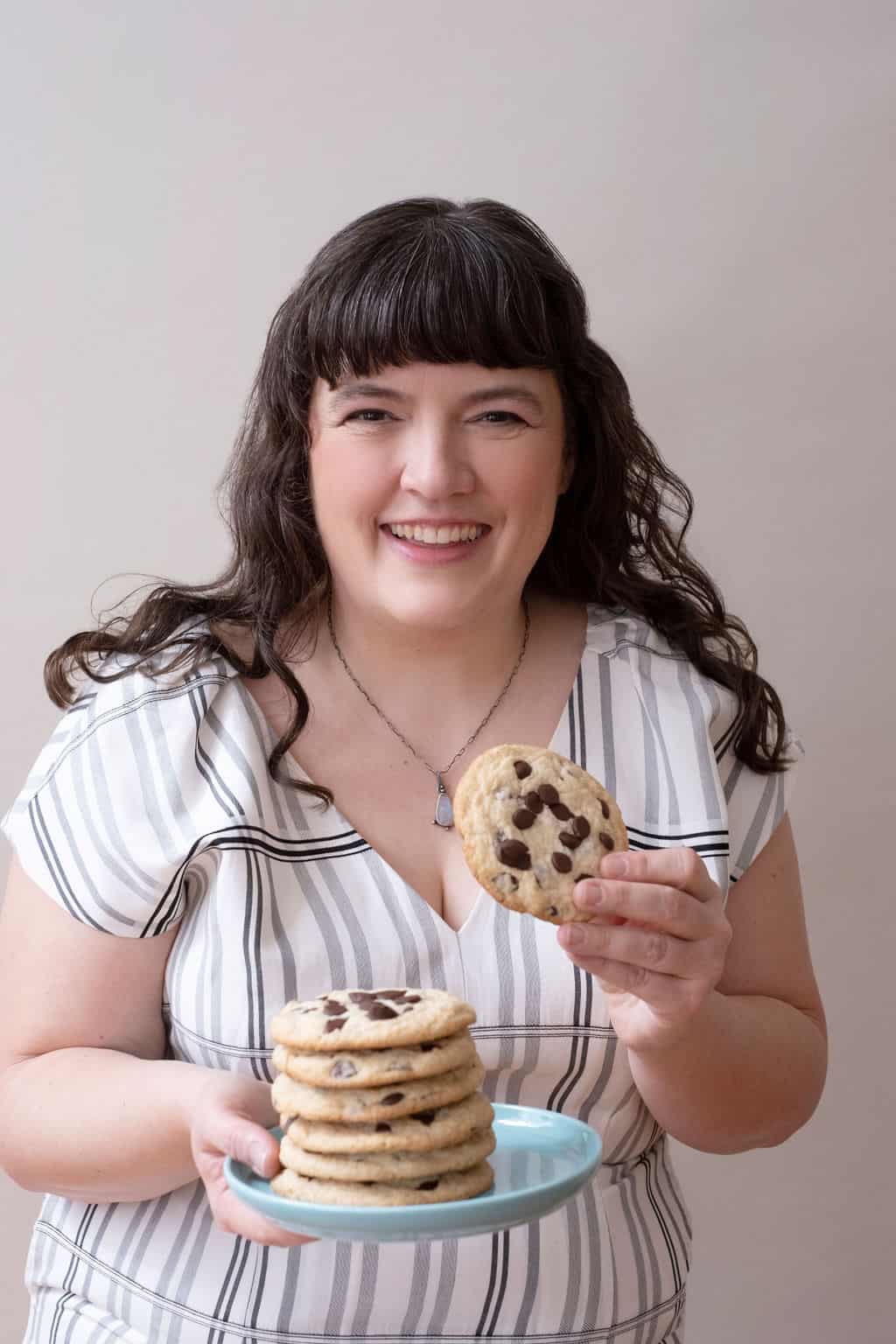 Photo of Tiffany Welsh holding a chocolate chip cookie.