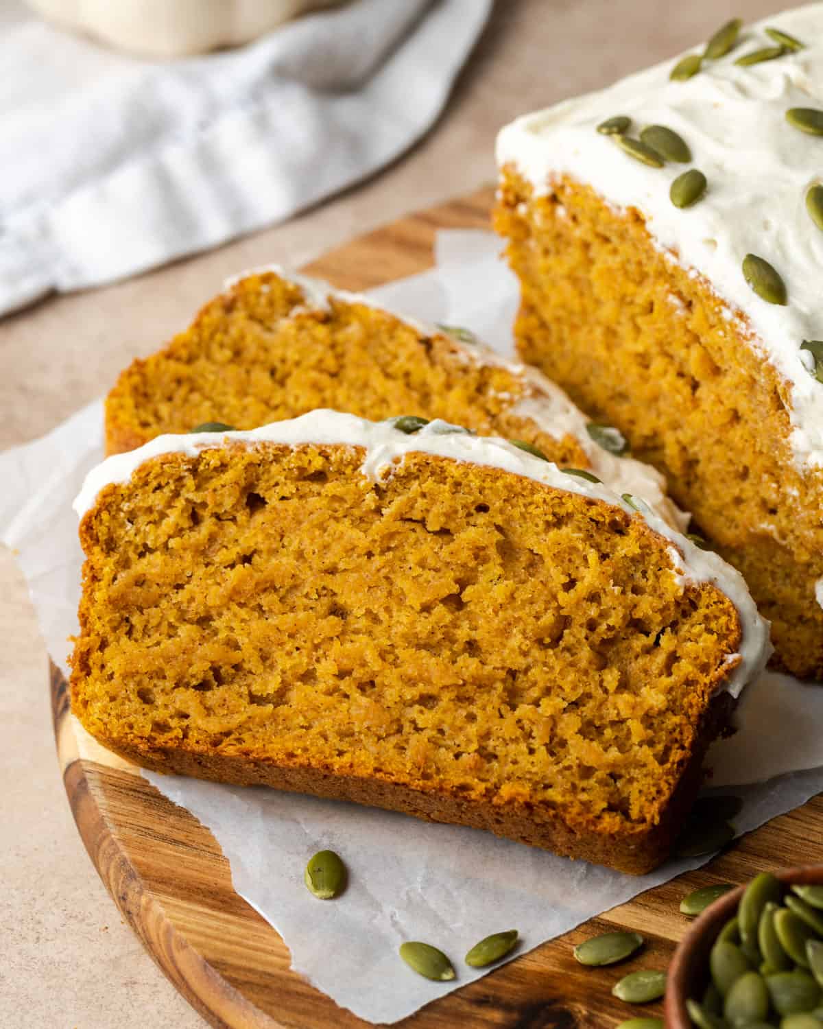 A sliced loaf of pumpkin bread on a wooden cutting board.