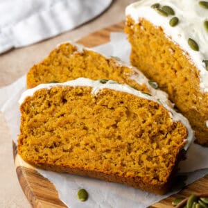 Sliced pumpkin bread on a wooden cutting board.