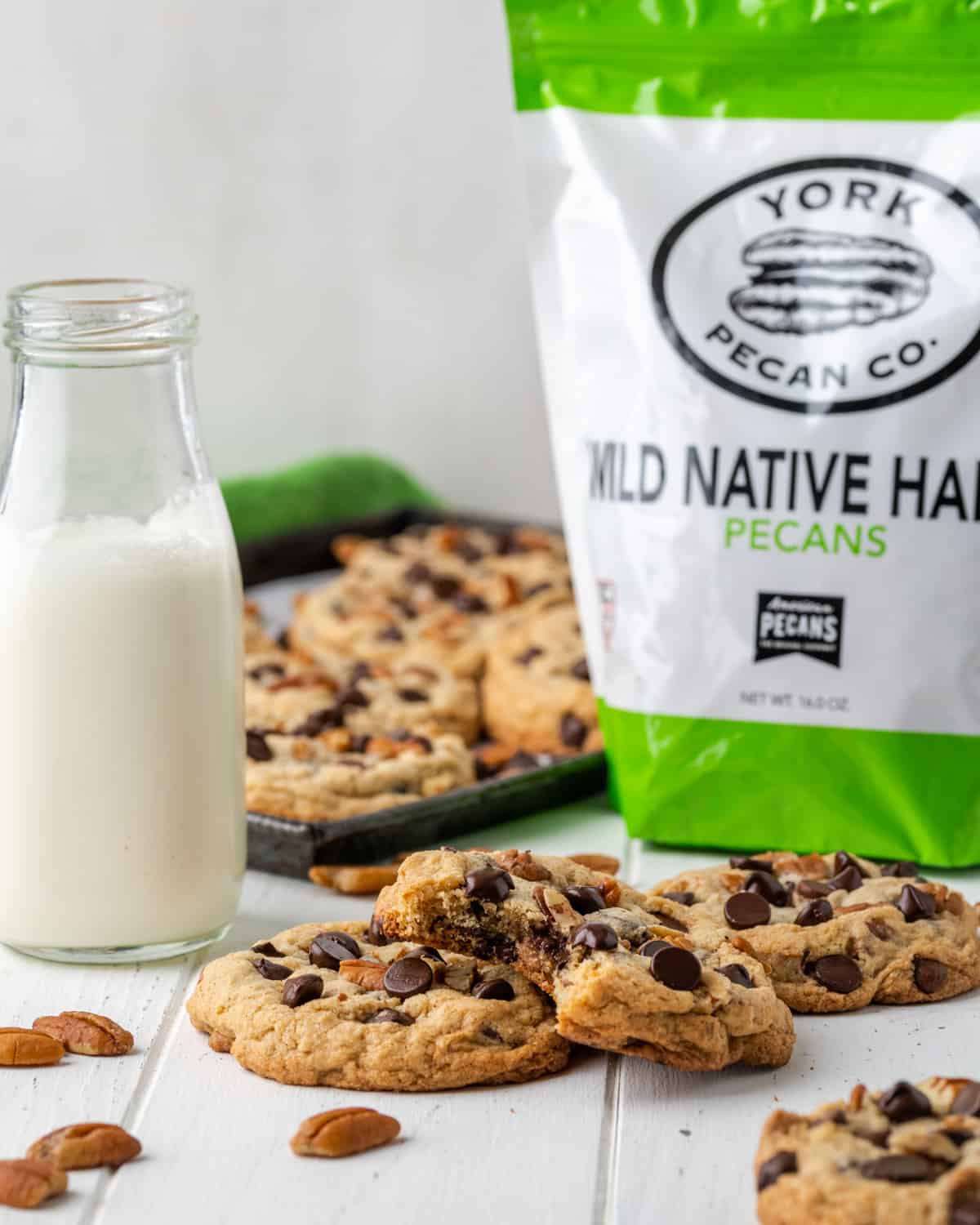 A bag of York Pecan co pecans with chocolate chip cookies on a white table.