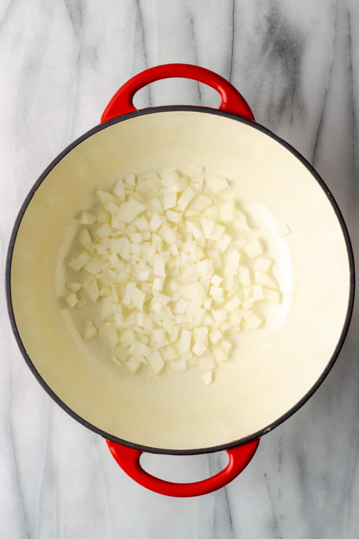 Onions being sauteed in a large dutch oven pot.