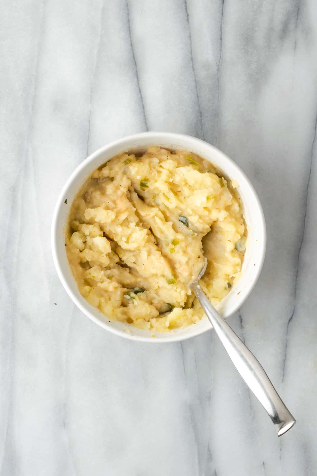 Potatoes and beans mashed together in a small bowl.