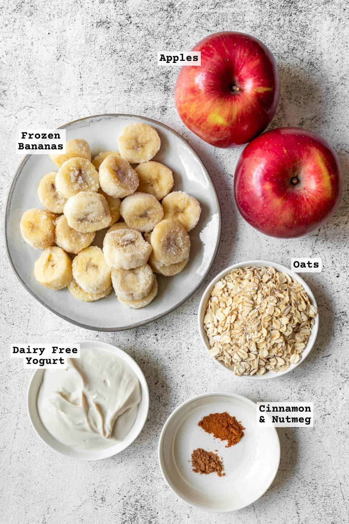 Ingredients for an apple smoothie on a white speckled tabletop.