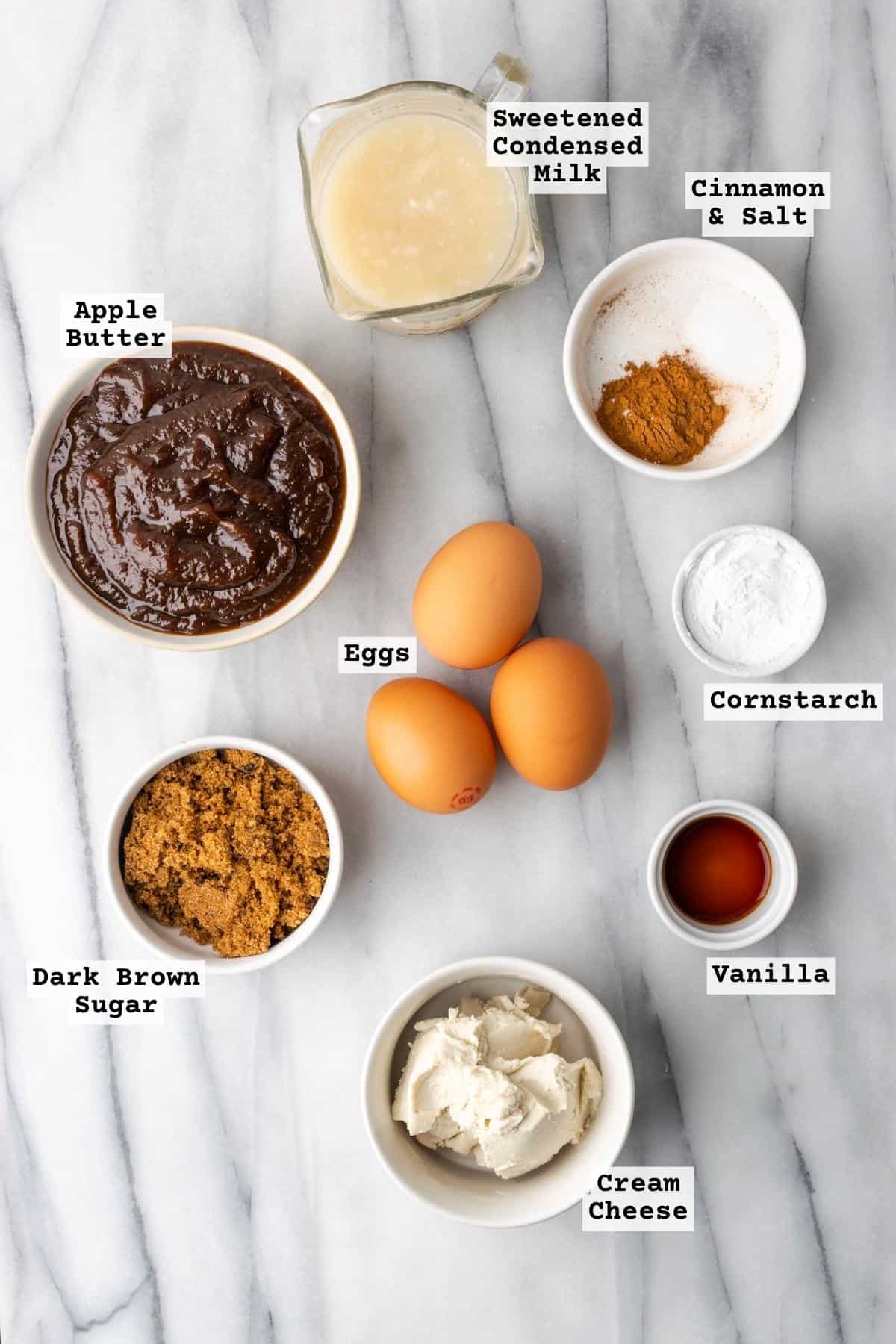 Ingredients for apple butter pie filling on a marble table.