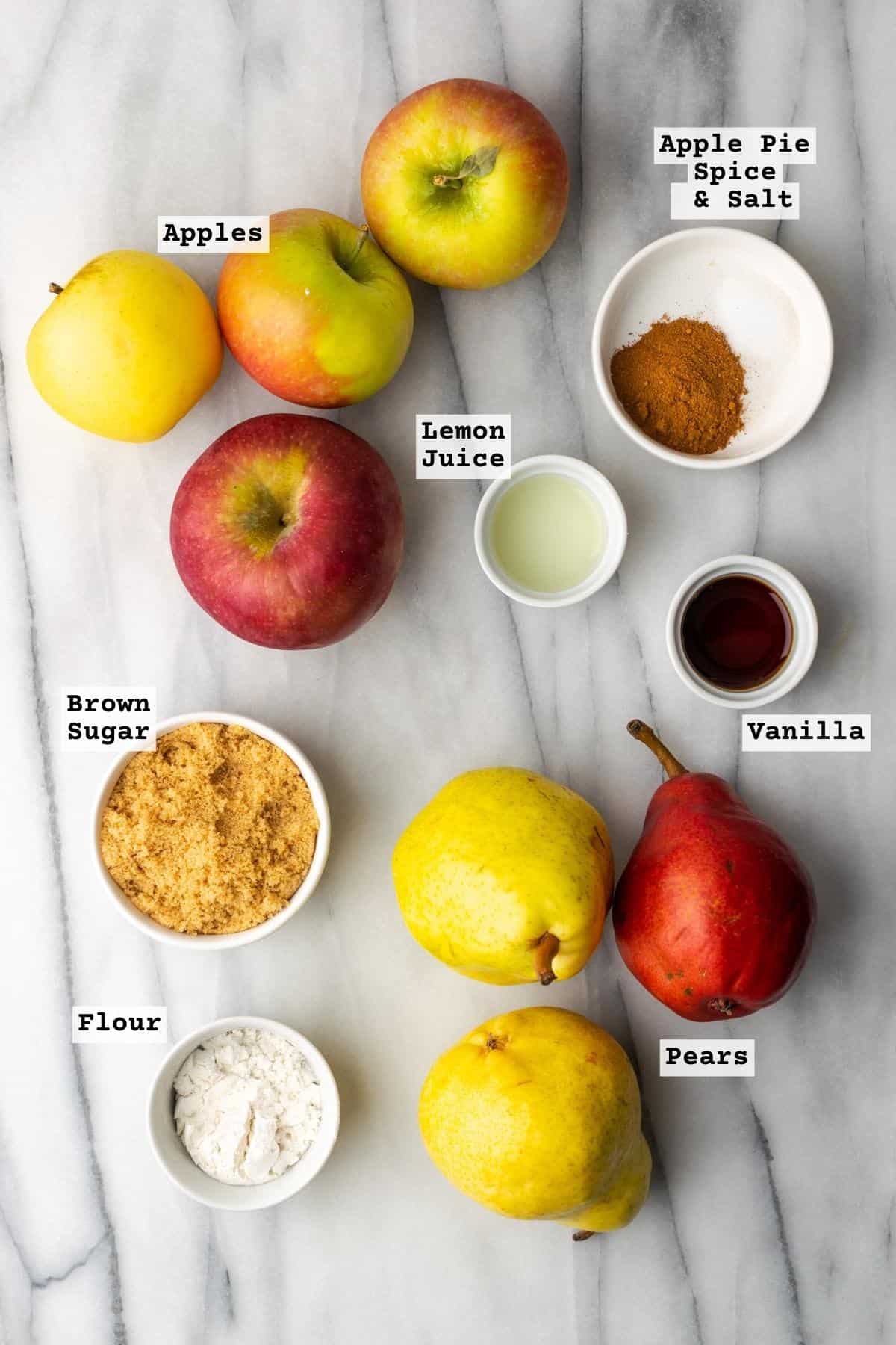 Ingredients for apple and pear pie on a marble table.