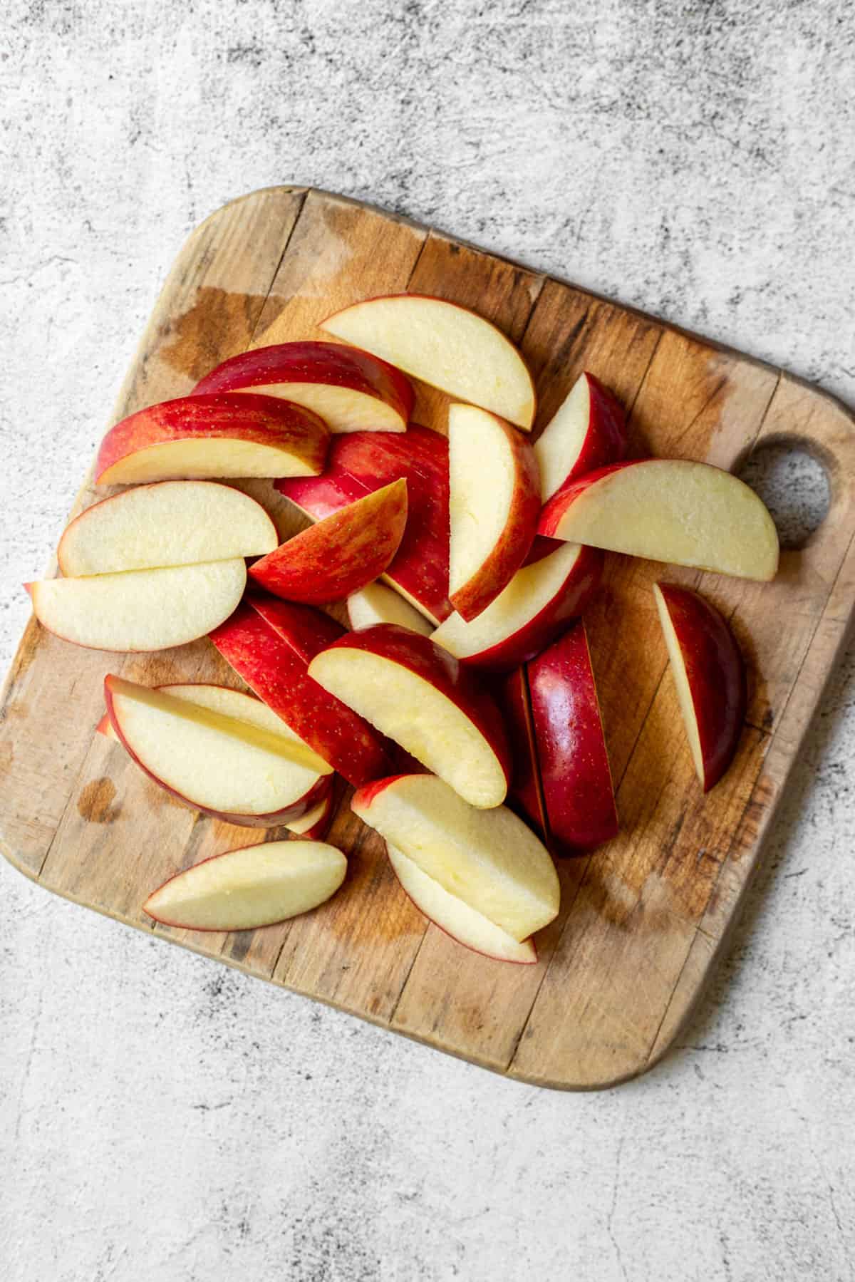 Sliced red apples on a cutting board.