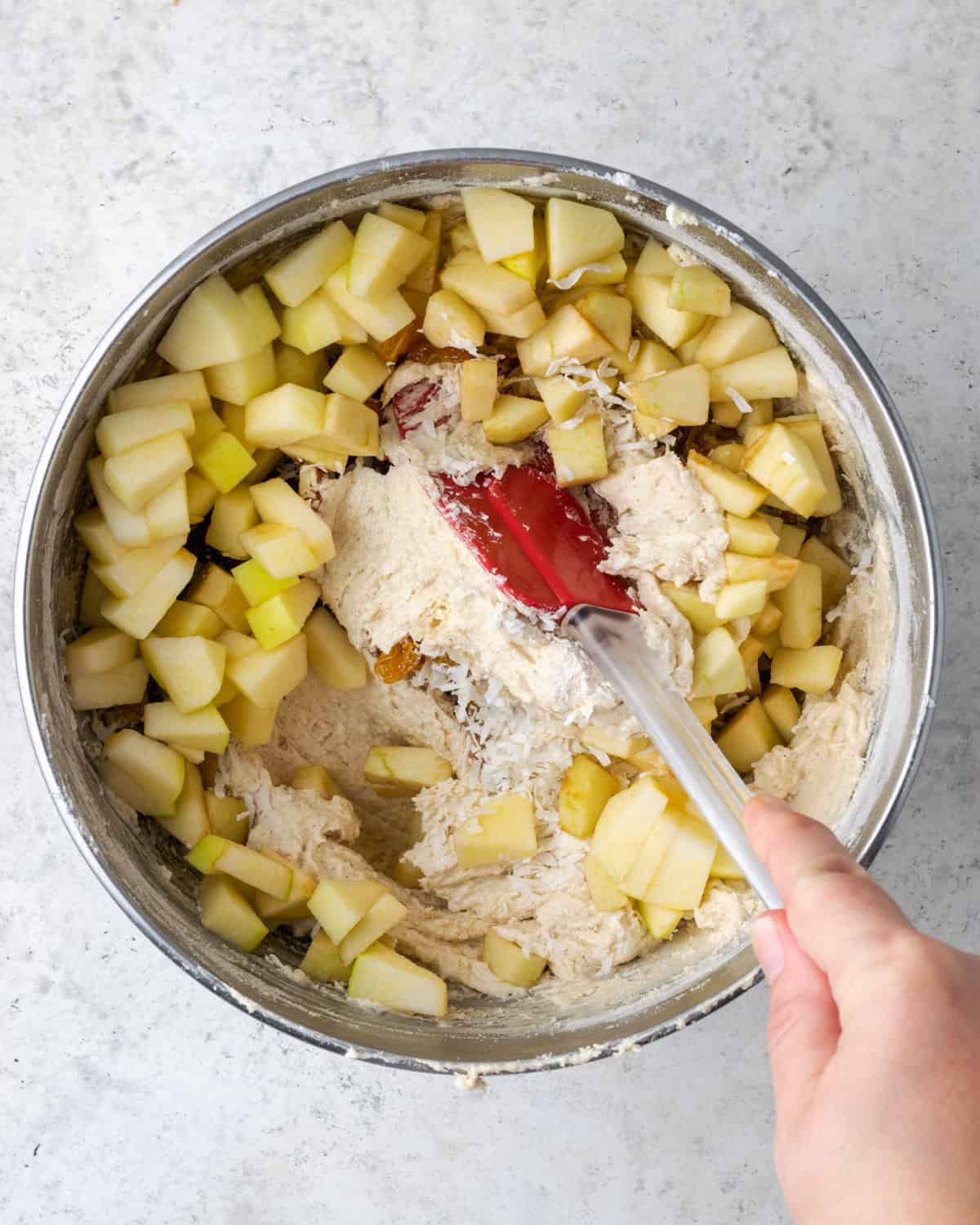 Fresh apples, coconut, pecans and raisins being added to the cake batter.