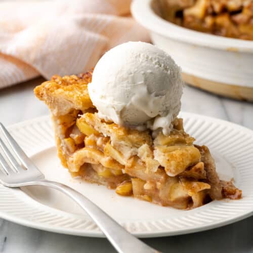 A slice of apple pear pie topped with vanilla ice cream.