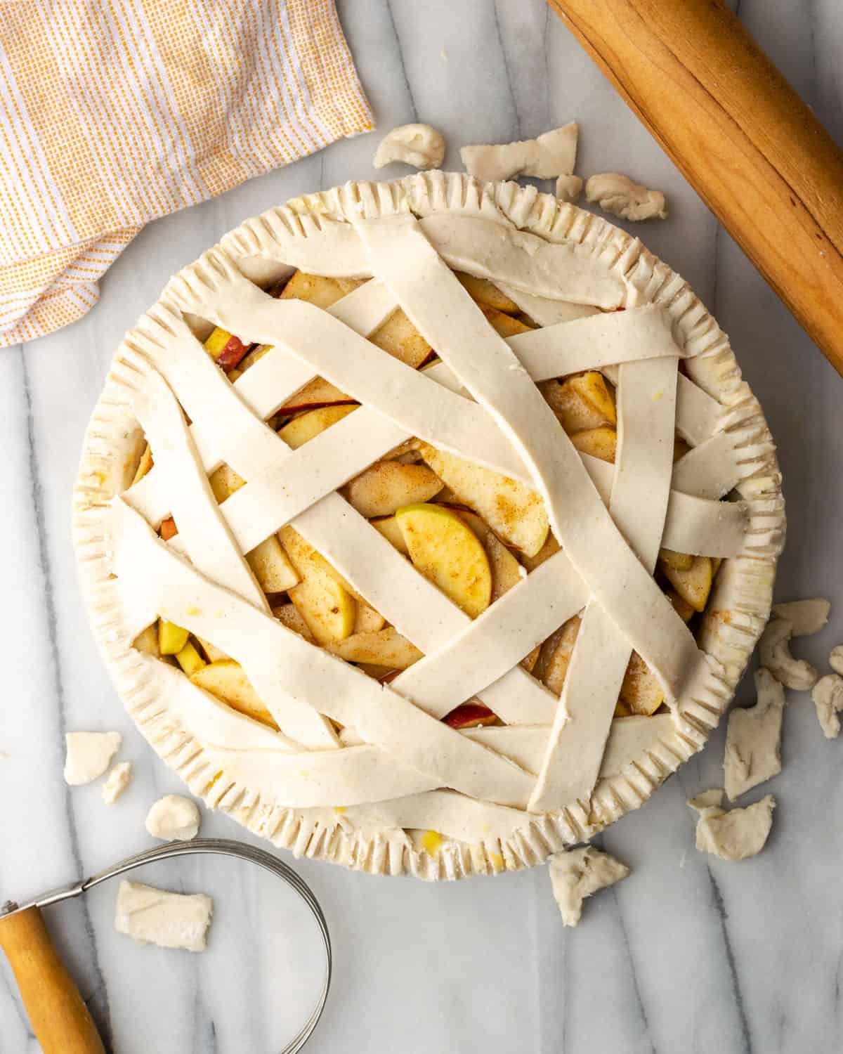 Unbaked apple and pear pie shown with a criss-cross lattice top.