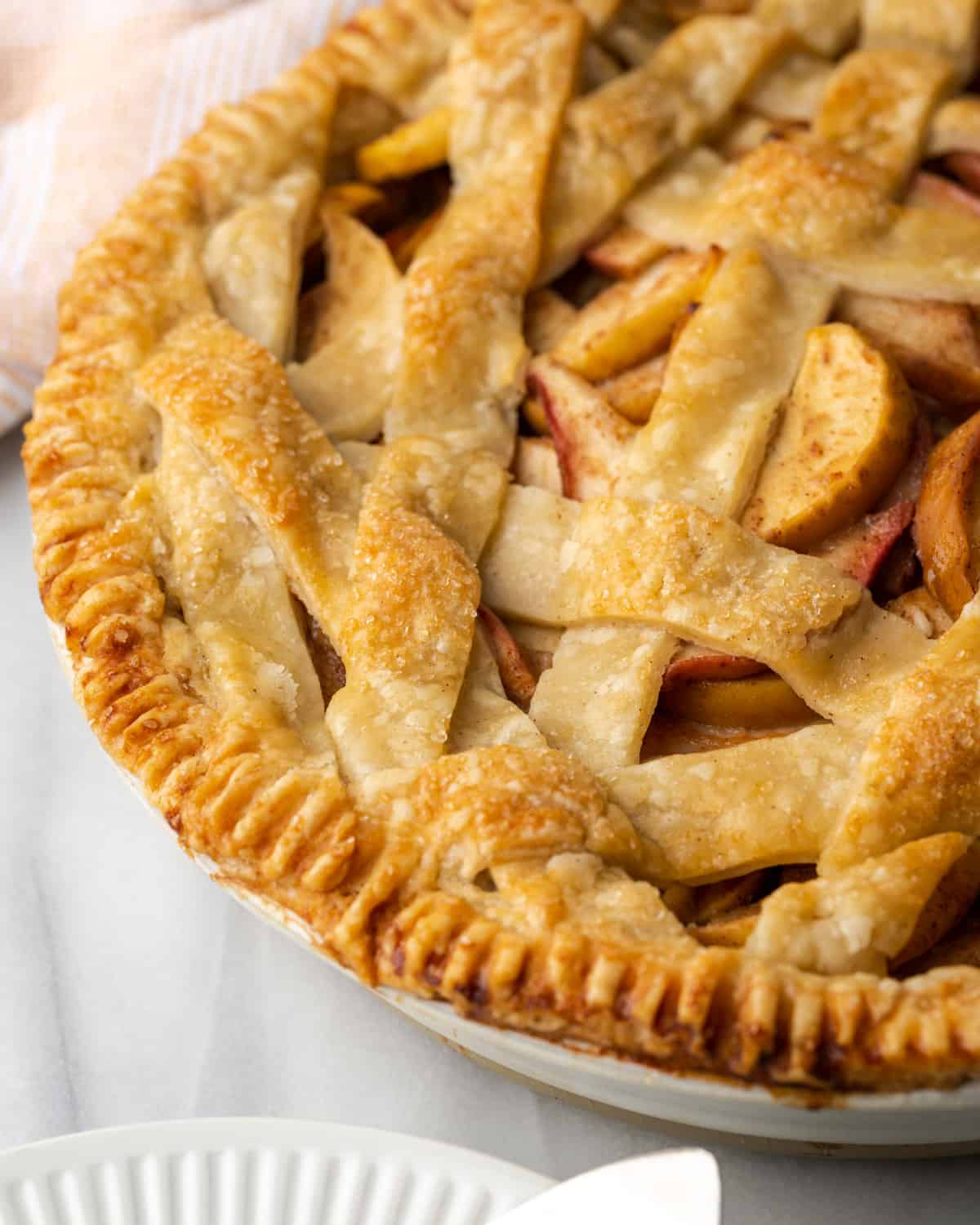 A freshly baked apple and pear pie on a white table.