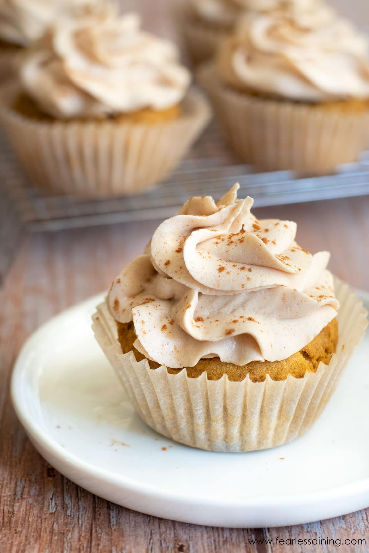 Gluten free pumpkin cupcake topped with a swirl of cinnamon frosting.