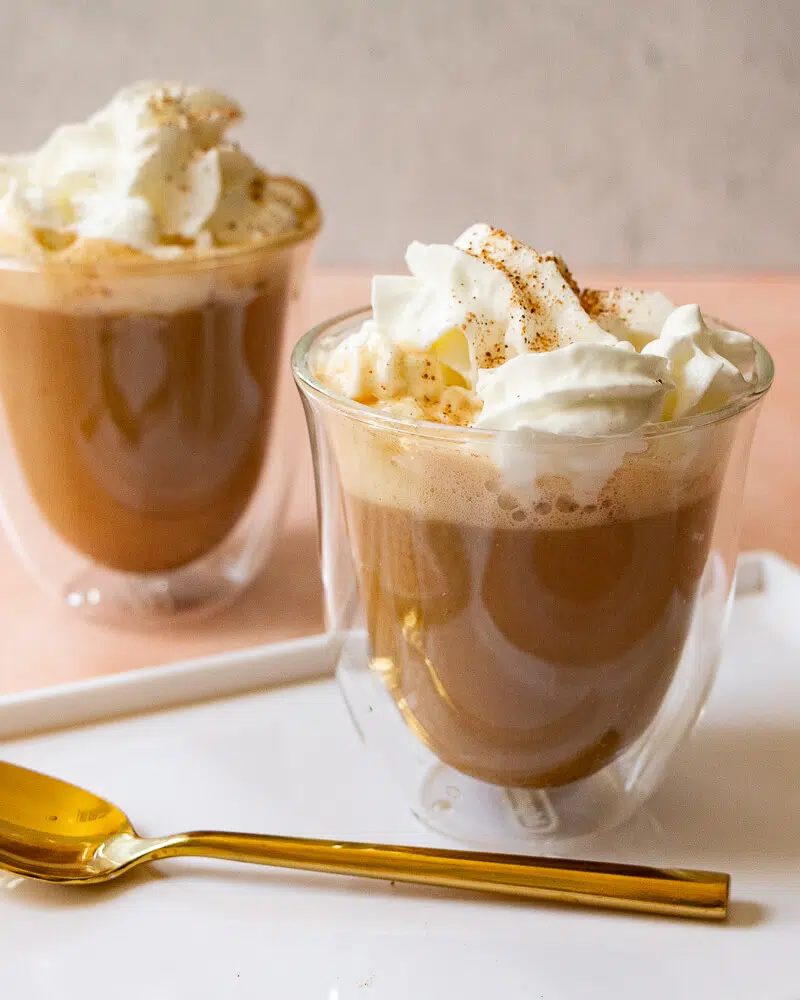 Two cups of pumpkin spice latte topped with whipped cream.