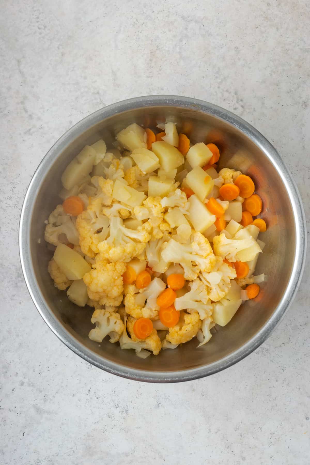 Cooked vegetables in a metal bowl.