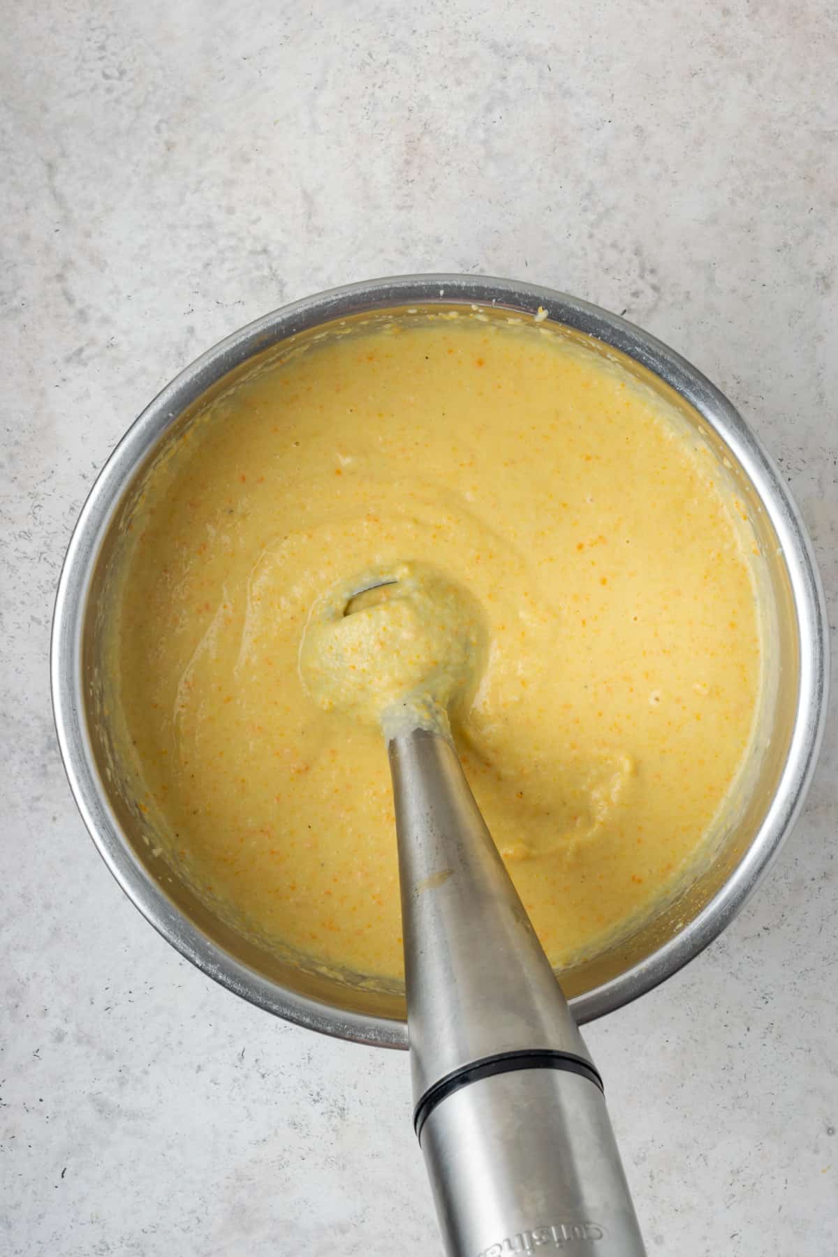 Vegetables being pureed with an immersion blender.  