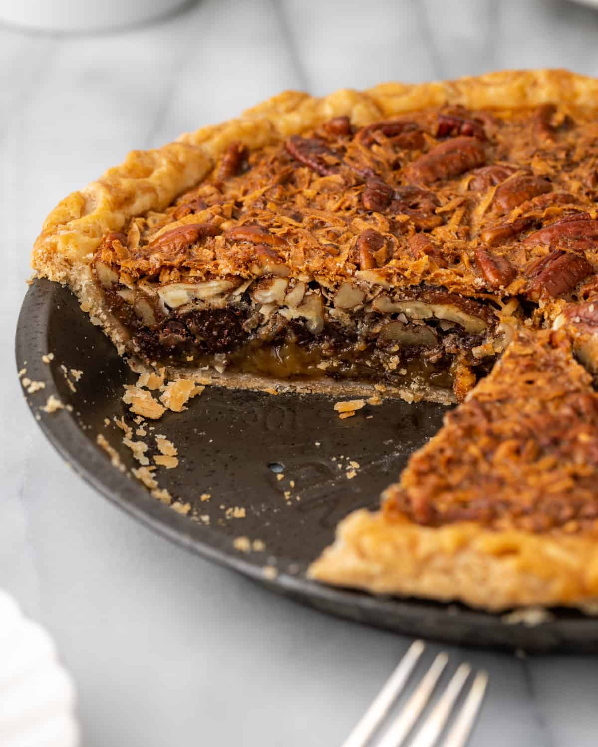 Interior of a sliced german chocolate pecan pie in a metal pie tin.