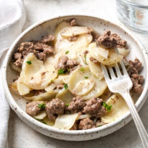 A bite being scooped out of a bowl of hamburger helper.