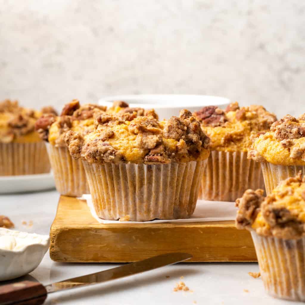 Sweet potato muffins cooling on a wooden cutting board.