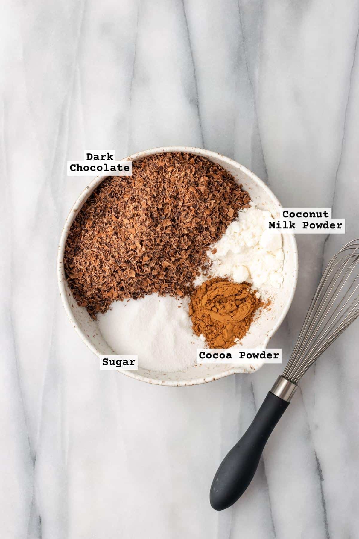 Ingredients for vegan hot chocolate mix in a ceramic bowl.