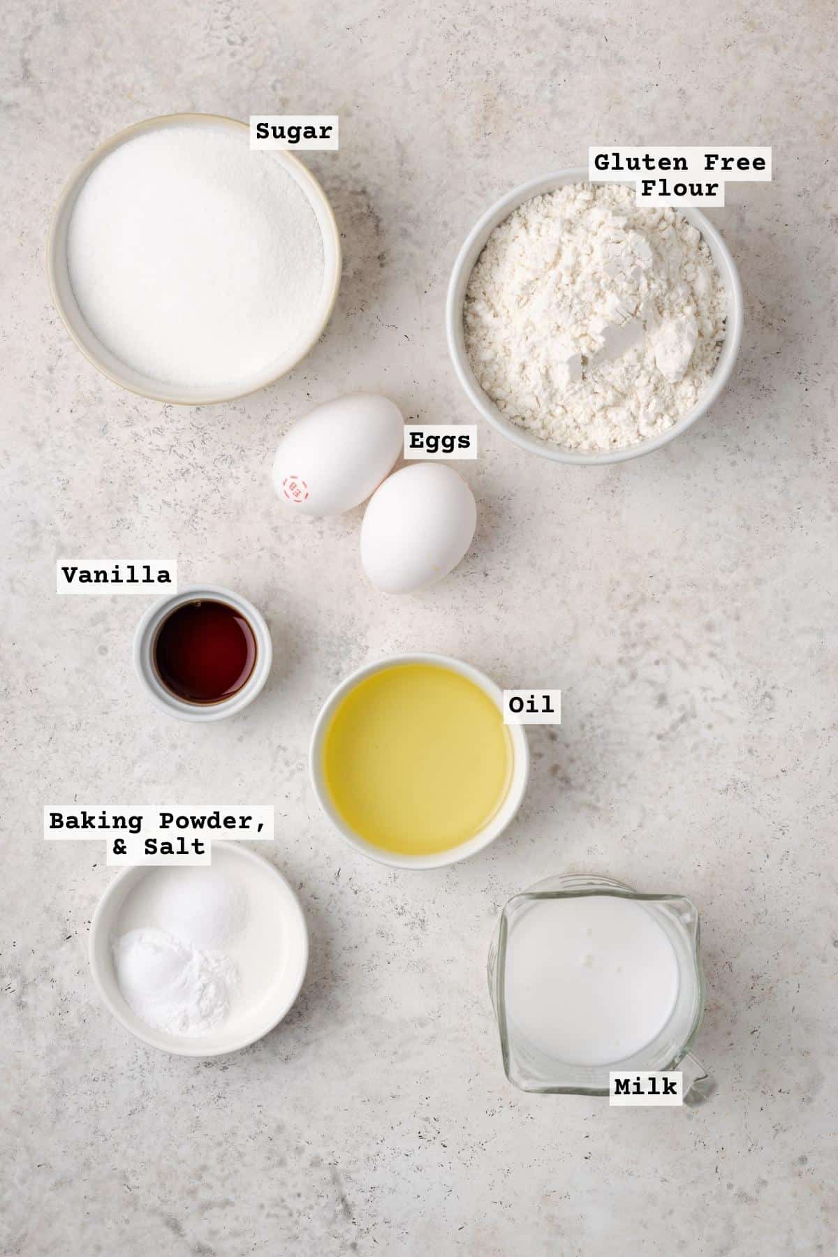 Ingredients for gluten free vanilla cupcakes on a white table.