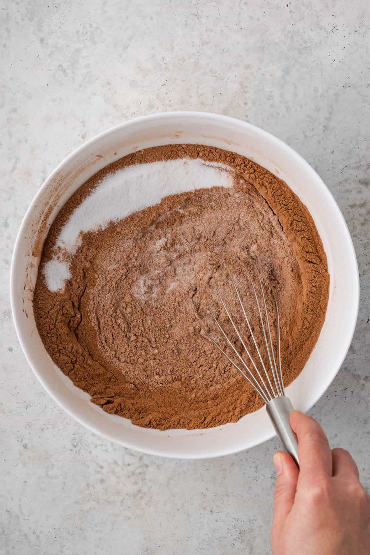 Sugar being whisked into the cocoa powder mixture.