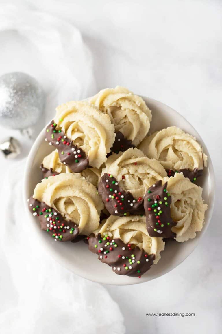 Gluten free butter cookies shaped into rosettes and dipped into chocolate.