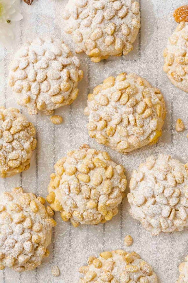 Cookies coated with pine nuts and powdered sugar.