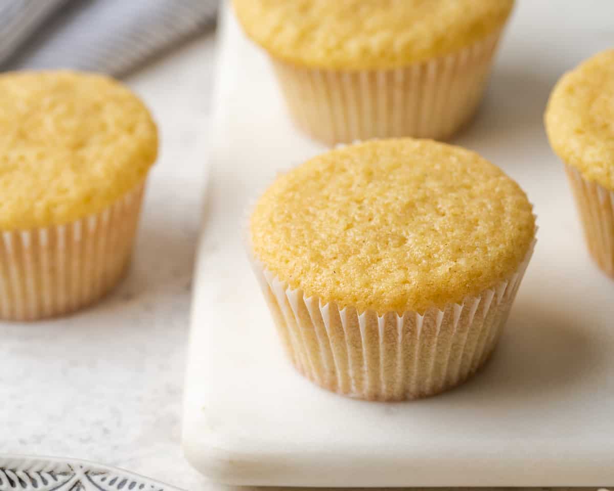 A closeup of baked gluten free vanilla cupcakes showing the flat tops. 