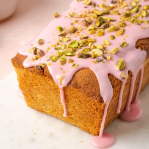 Blood orange pound cake topped with pink icing and chopped pistachios.
