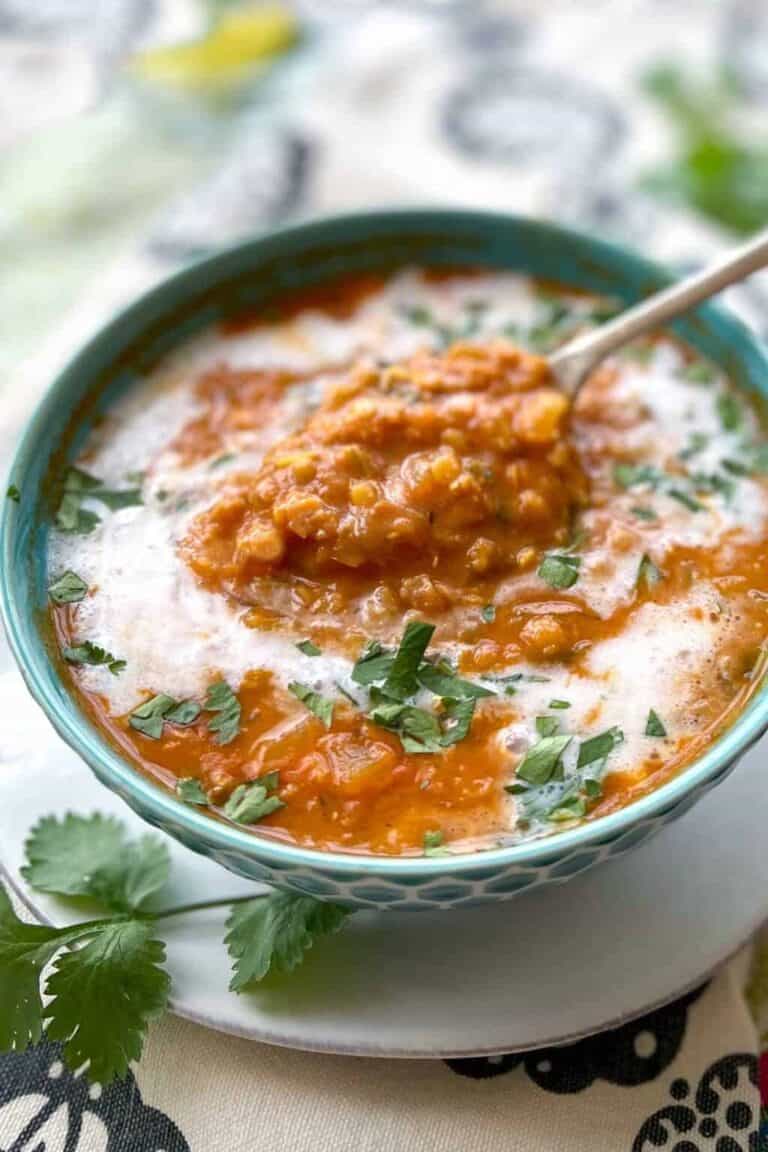 Coconut, tomato and red lentil soup garnished with fresh cilantro.