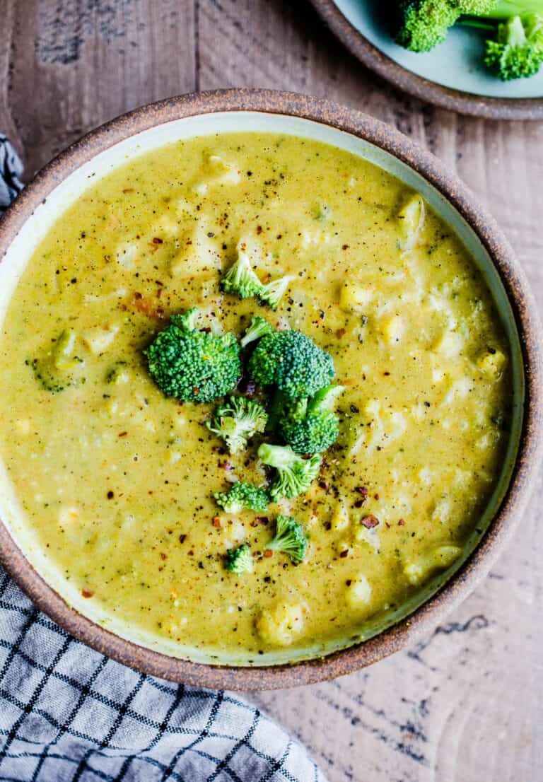 A bowl of curried broccoli and cauliflower soup topped with broccoli florets.