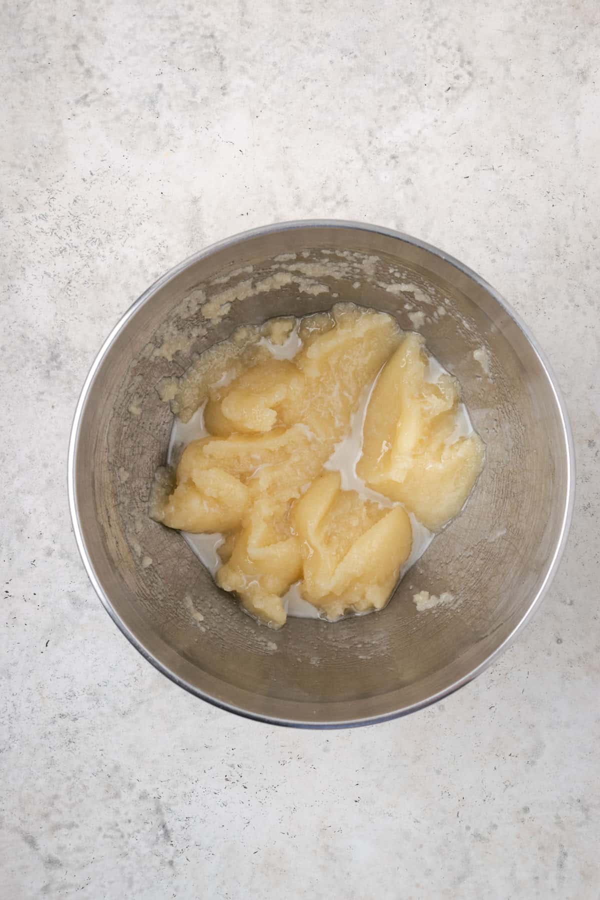 Oil and sugar beaten together in a large metal mixing bowl.