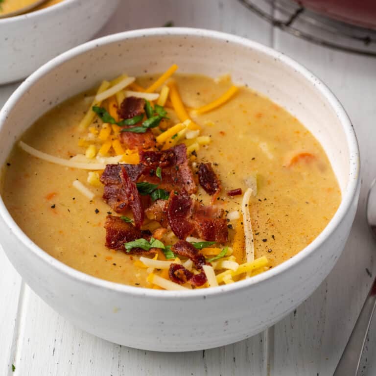 Gluten free potato soup garnished with bacon and shredded cheese.