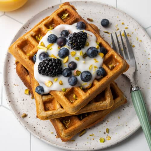 A stack of gluten free oat flour waffles on a white plate.
