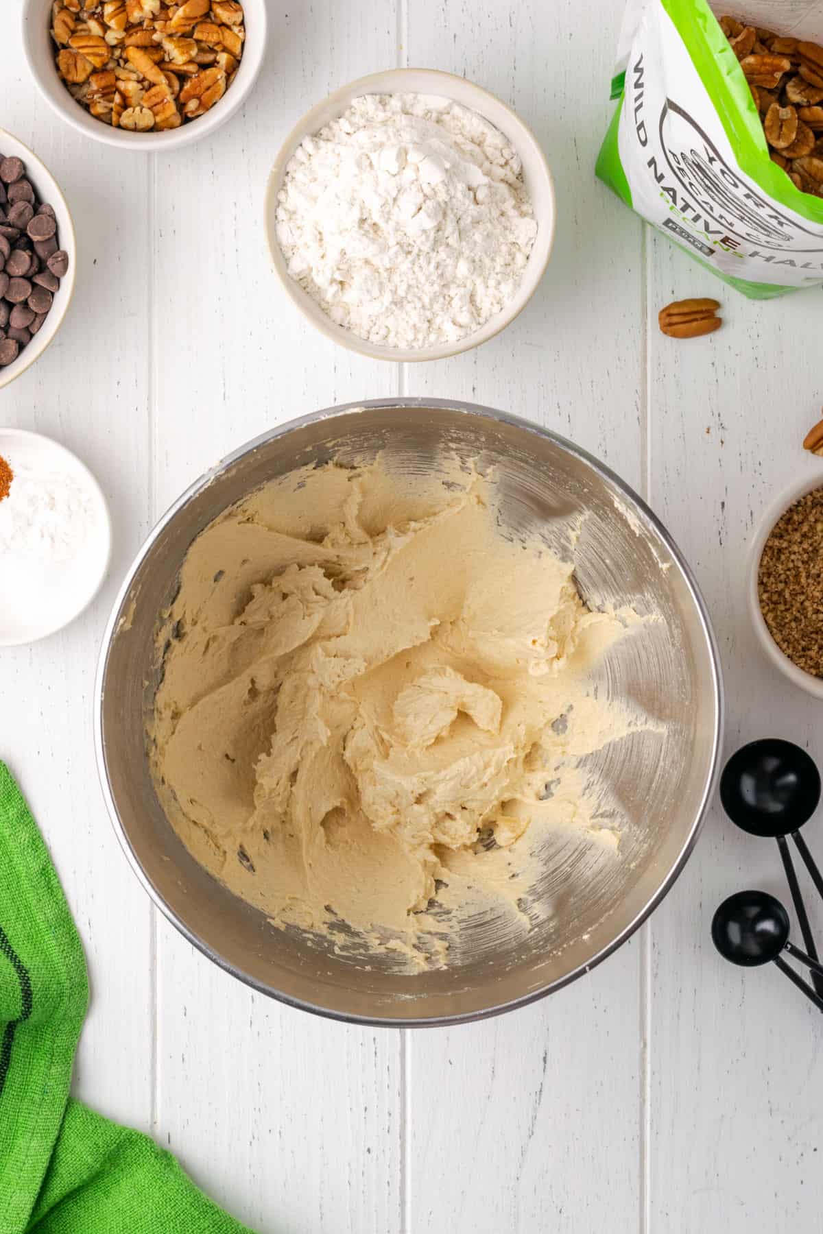 Butter and sugar beaten with eggs and vanilla in a large metal mixing bowl.