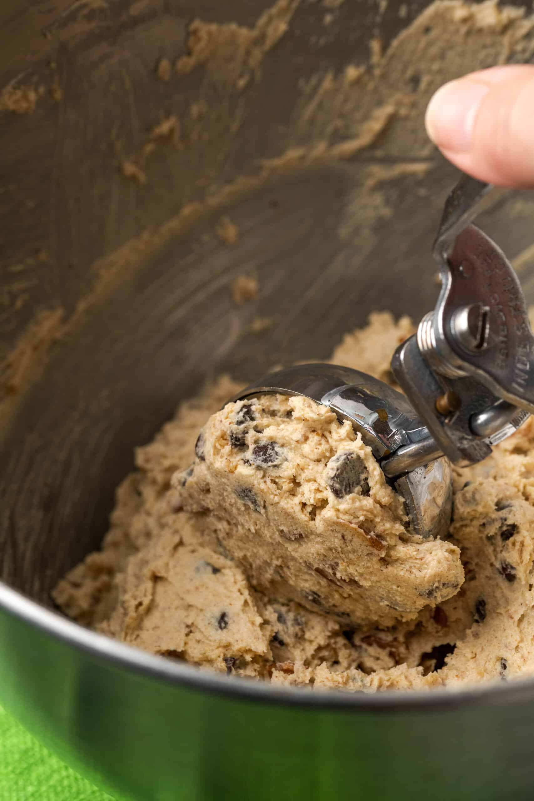 A scoop portioning cookie dough into large balls.