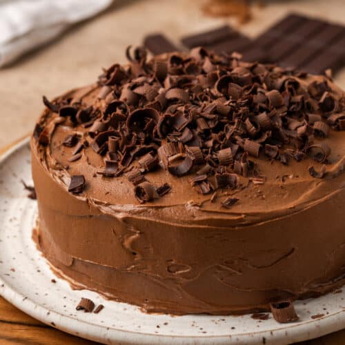 A 6 inch chocolate cake topped with chocolate frosting and chocolate shavings.