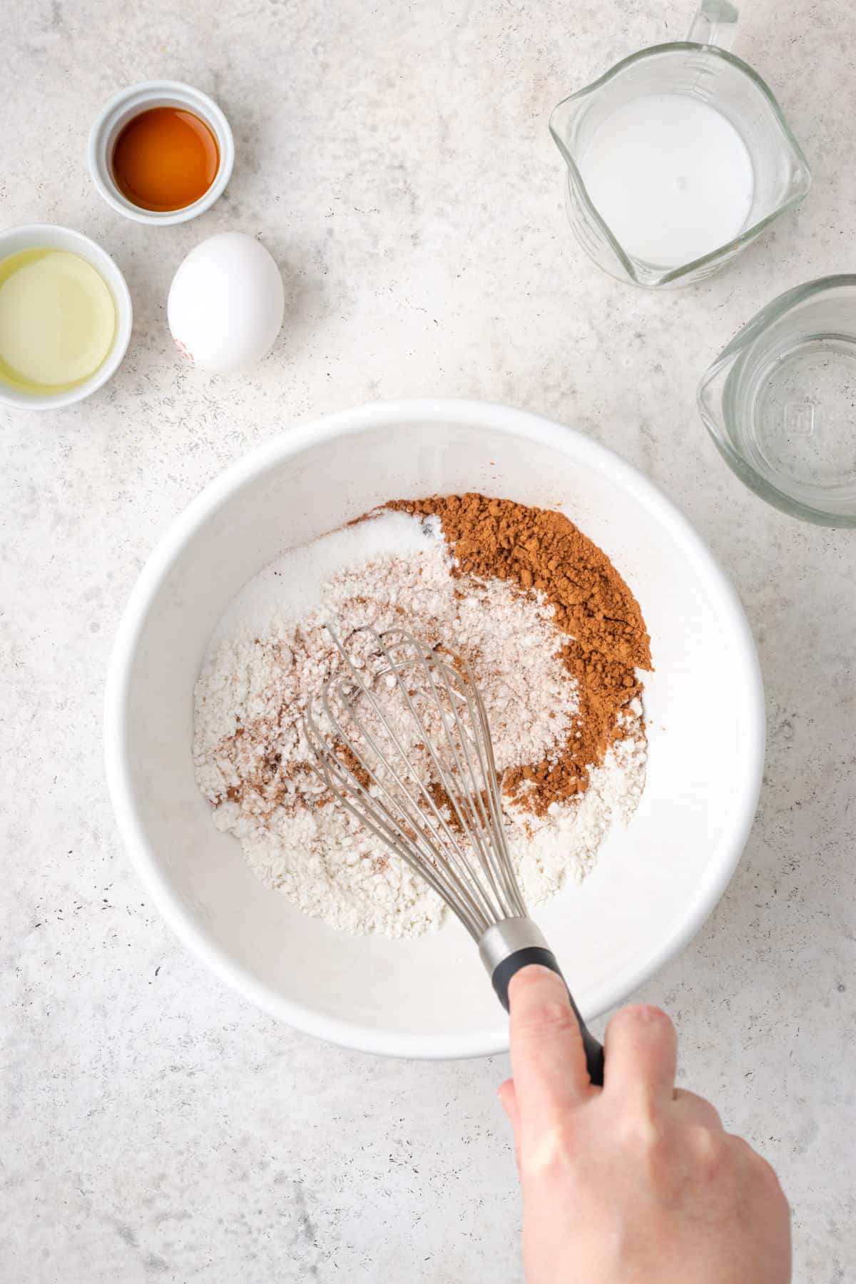 Dry ingredients being whisked together in a large white bowl.