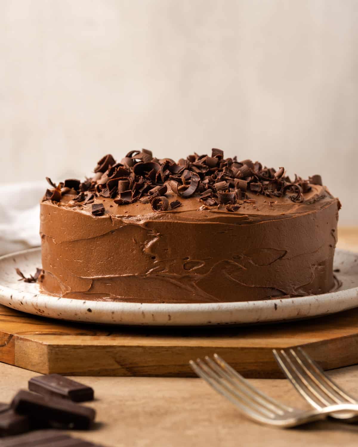 A small chocolate cake covered with chocolate frosting and chocolate curls.