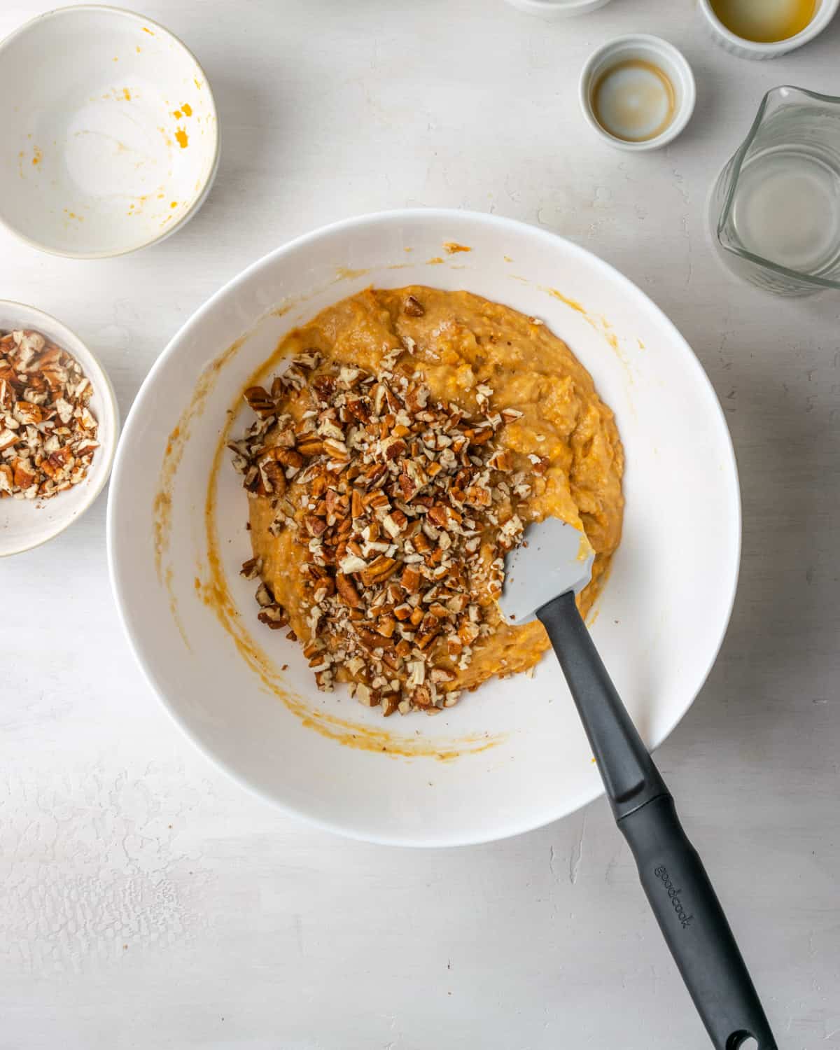 A pile of chopped pecans on top of an orange batter.