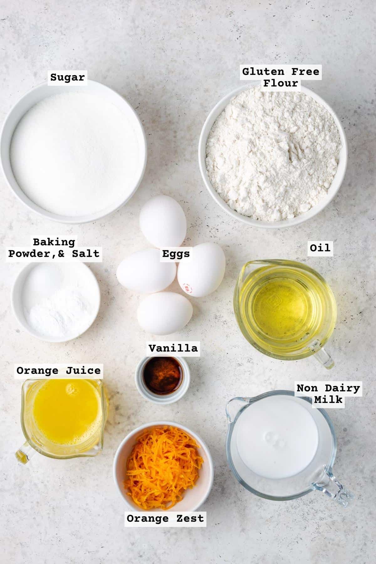 Ingredients for gluten free orange cake on a white table.