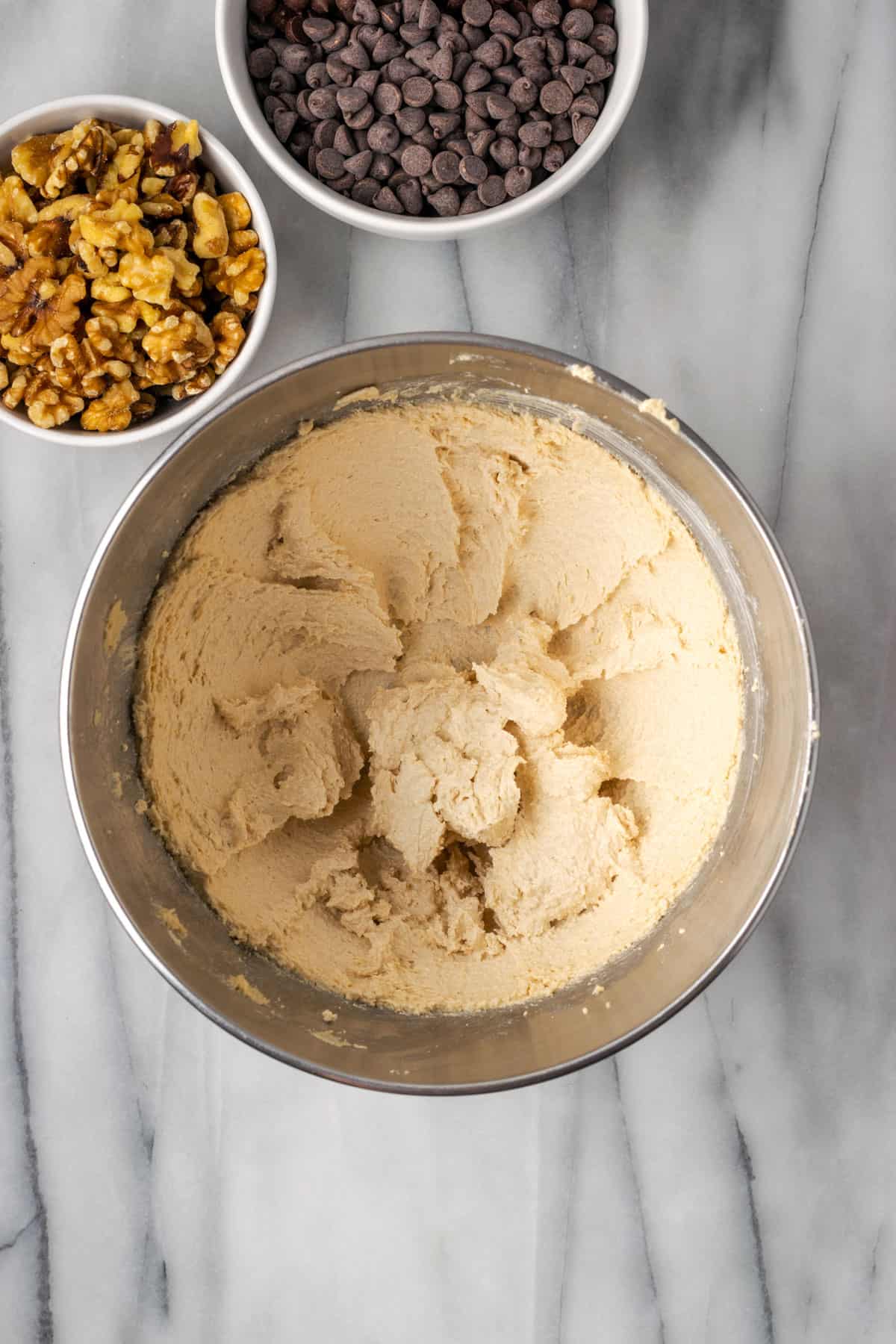 Butter and sugars creamed together until fluffy in a large metal mixing bowl.