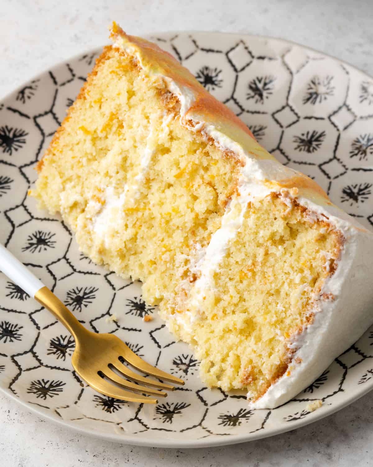 A slice of gluten free orange cake served on a small dessert plate.