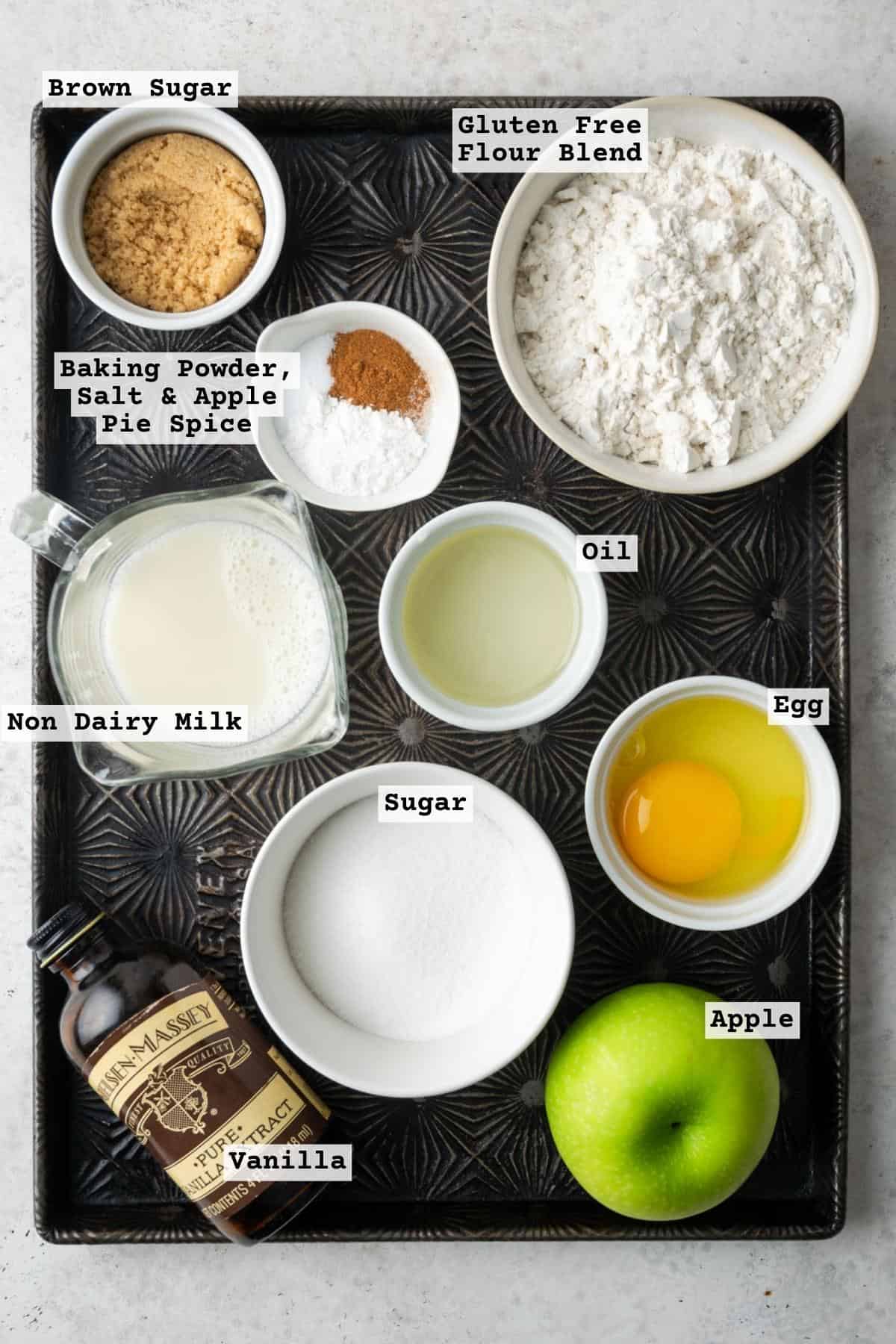 Ingredients for gluten free apple muffins on a metal baking tray.