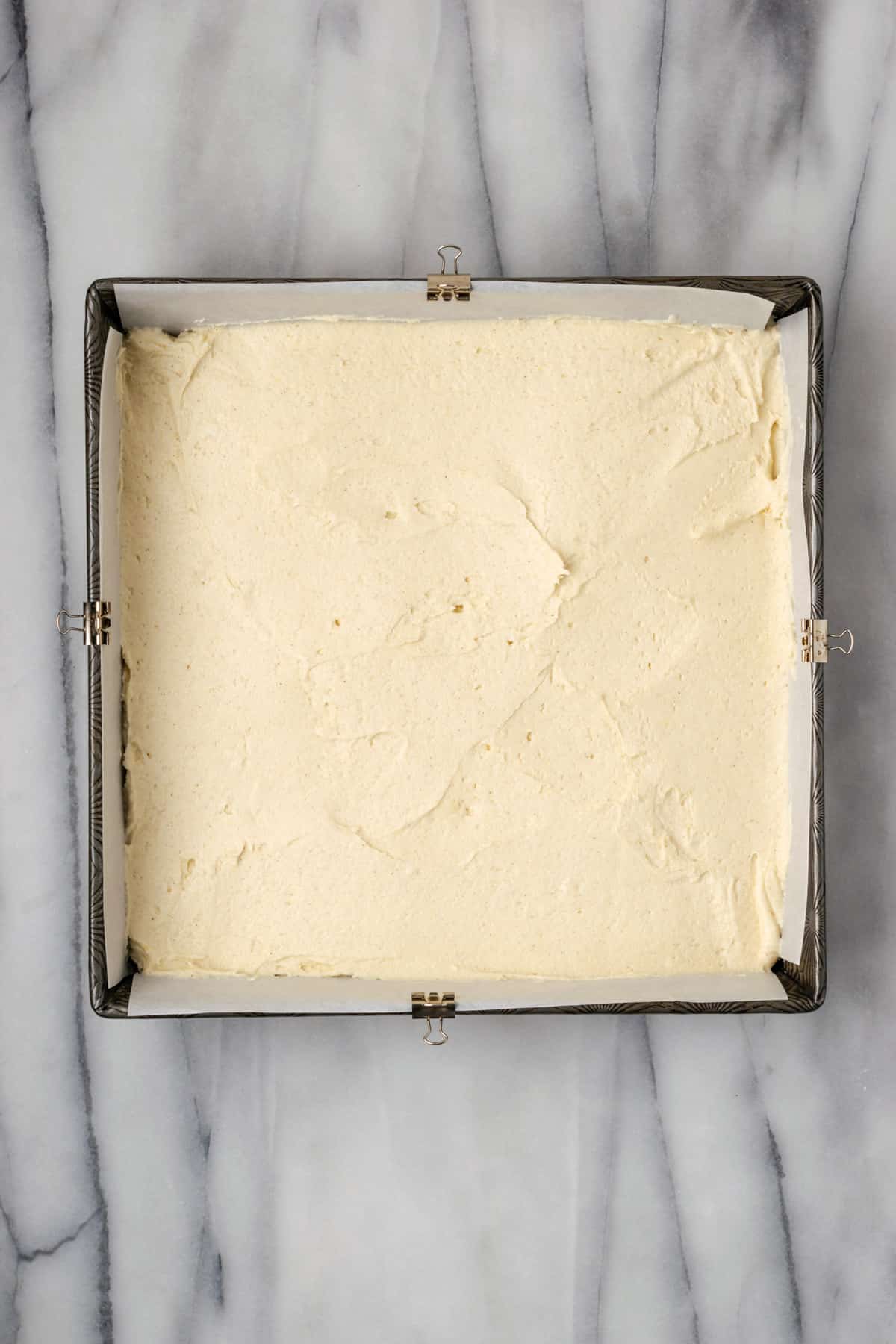 Crumb cake batter spread into a square baking pan.