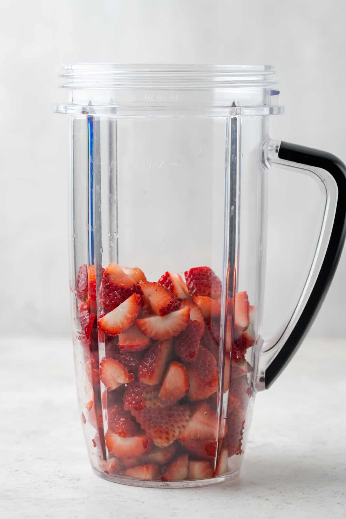 Sliced strawberries in a blender. 